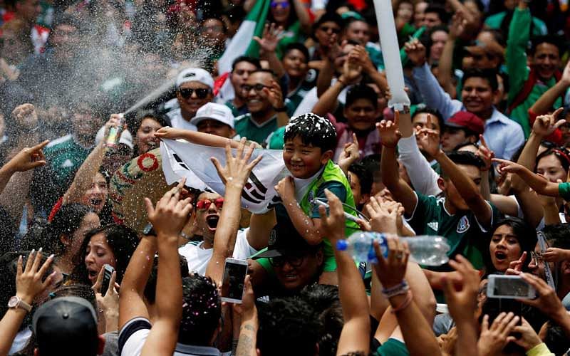  Mexican fans celebrate with a young South Korean citizen. (Reuters Photo)