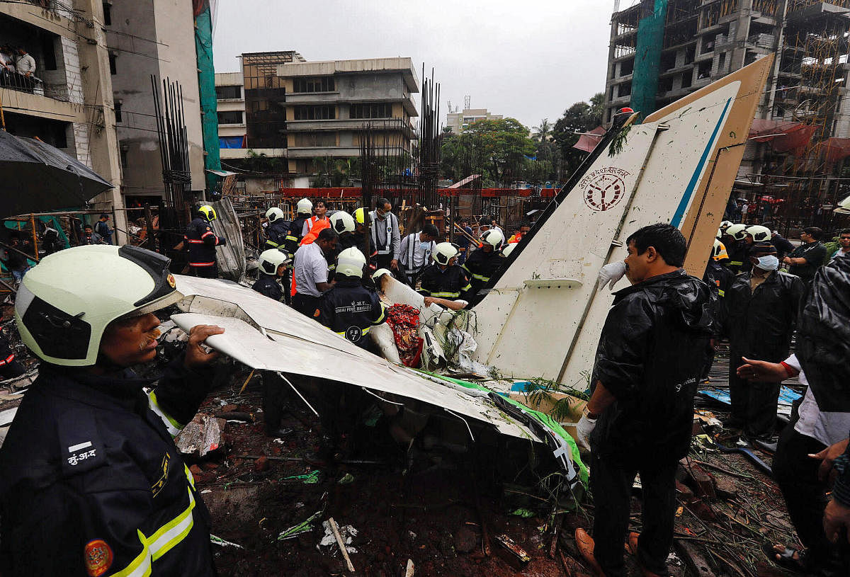 Firefighters inspect the site of a plane crash in Mumbai on Thursday. Reuters