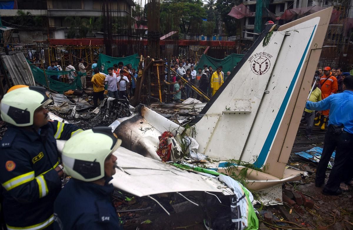 Fire-fighters work at the site of the chartered plane that crashed at Ghatkopar's Jivdaya Lane, in Mumbai on Thursday. Five persons were killed when a King Air C90 12-seater aircraft on a test flight crashed in a crowded Mumbai suburb. (PTI Photo)
