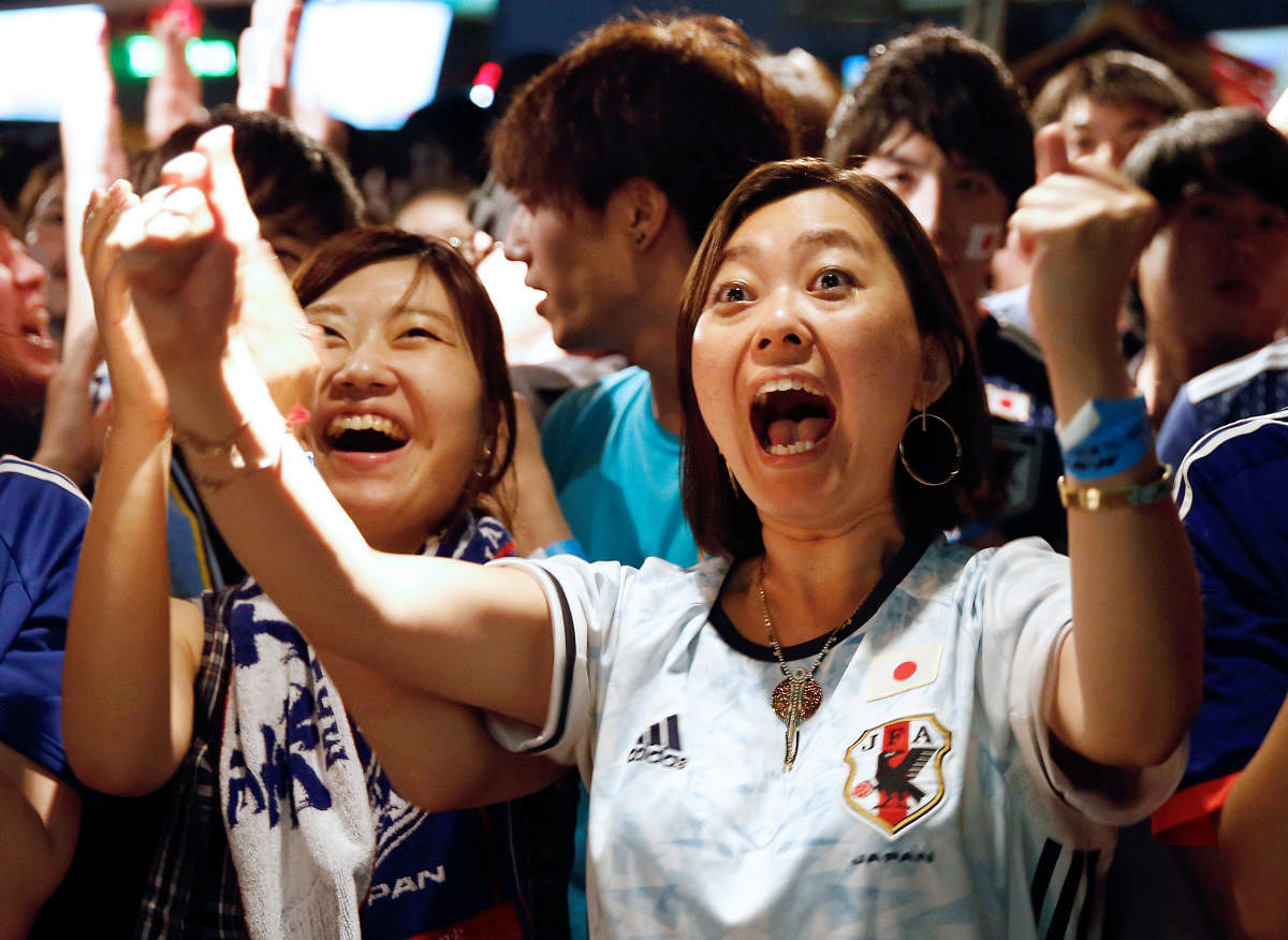THRILLED: Japanese fans react as they watch a broadcast of their country's World Cup Group H game against Poland. Reuters 