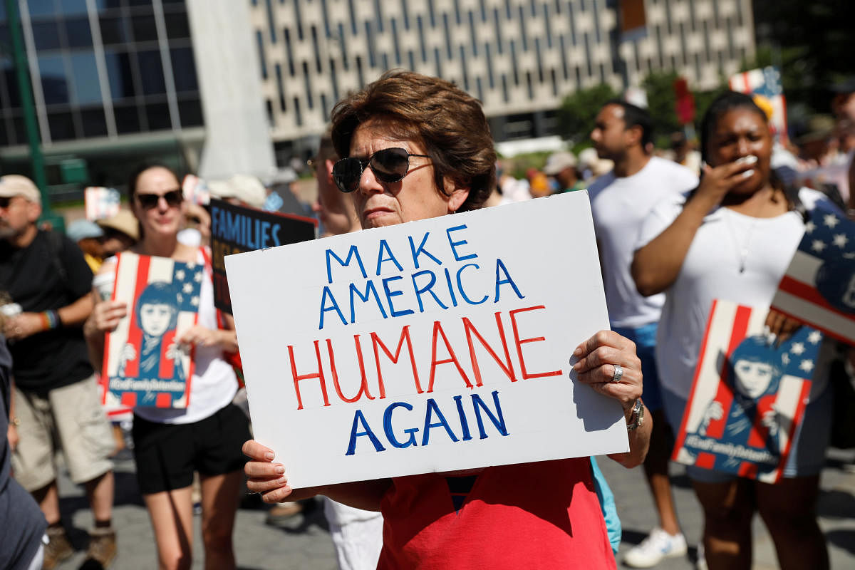 A demonstrator holding a sign participates in "Keep Families Together" march to protest Trump administration's immigration policy in Manhattan, New York. (Reuters Photo)