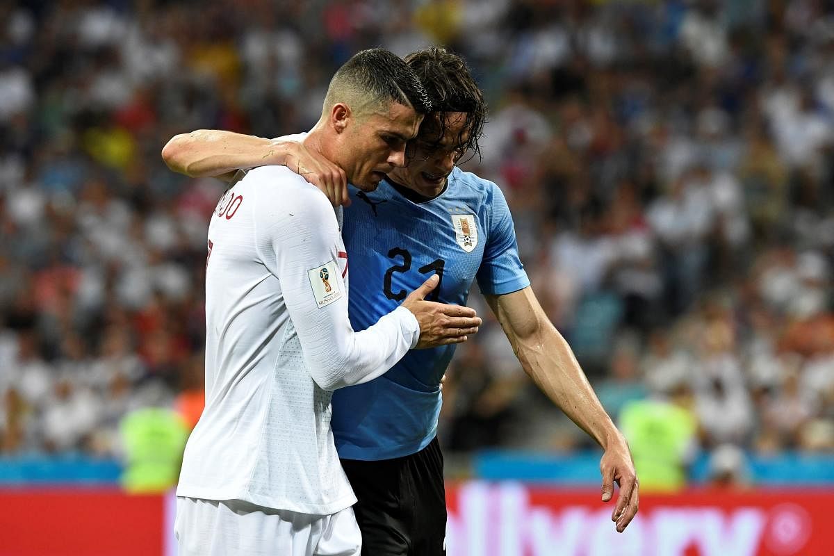 MATESHIP Edinson Cavani (right), who scored both of Uruguay's goals in their 2-1 win over Portugal, is helped off the pitch by his rival forward Cristiano Ronaldo. AFP