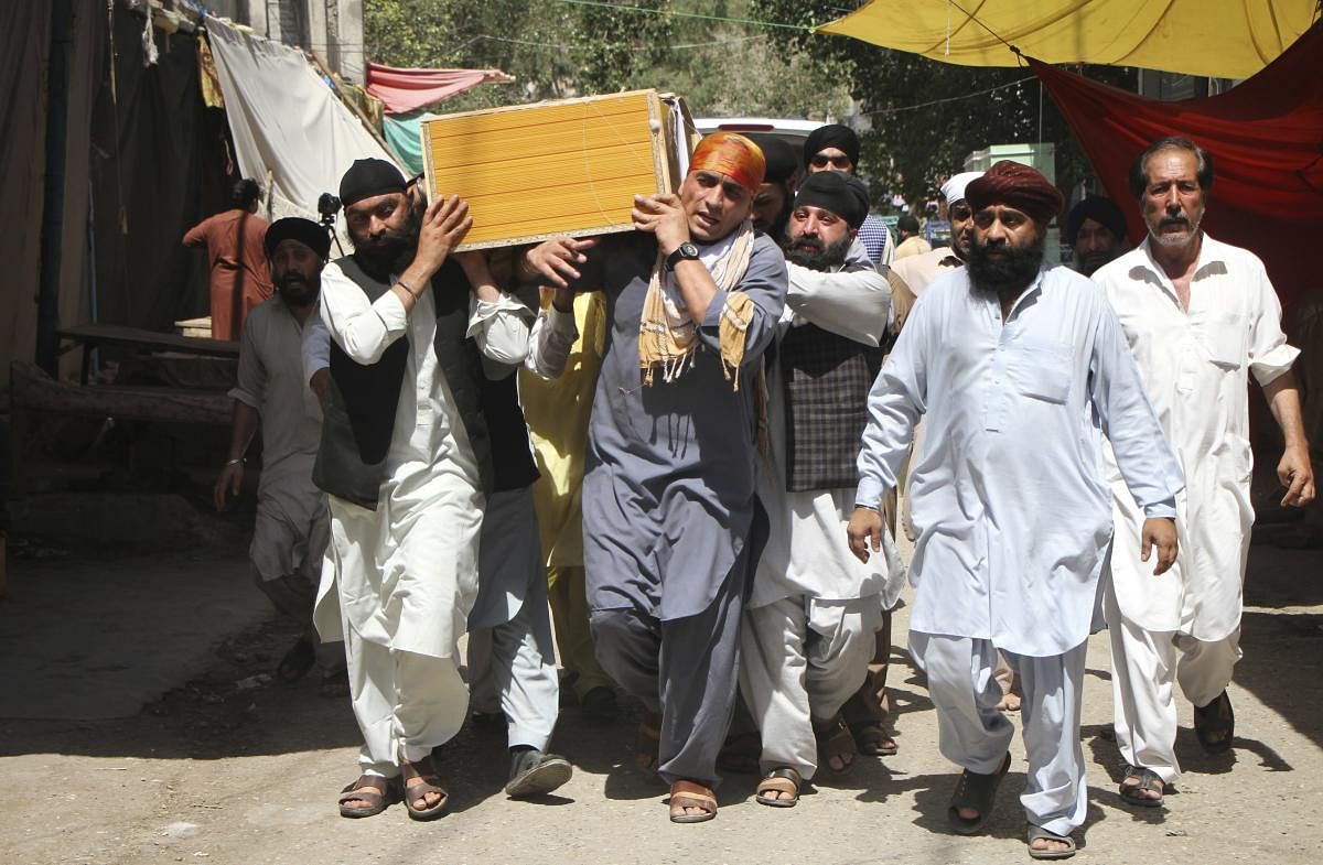 Sikh minorities carry the coffin of a relative killed in Jalalabad, Afghanistan. The Islamic State group has claimed responsibility for a suicide bombing in eastern Afghanistan that killed at least 19 people, mostly Sikhs and Hindus.