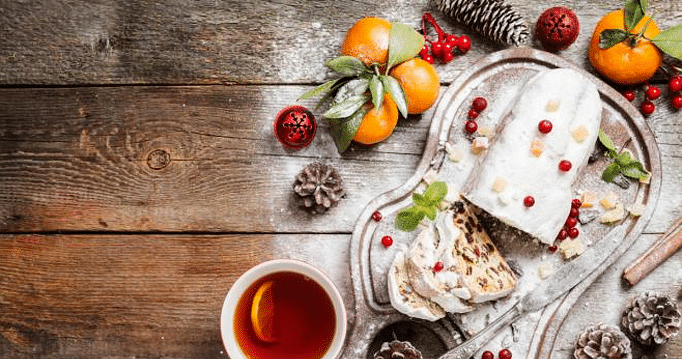 Christmas stollen, traditional German, European festive dessert cut into pieces on wooden background.