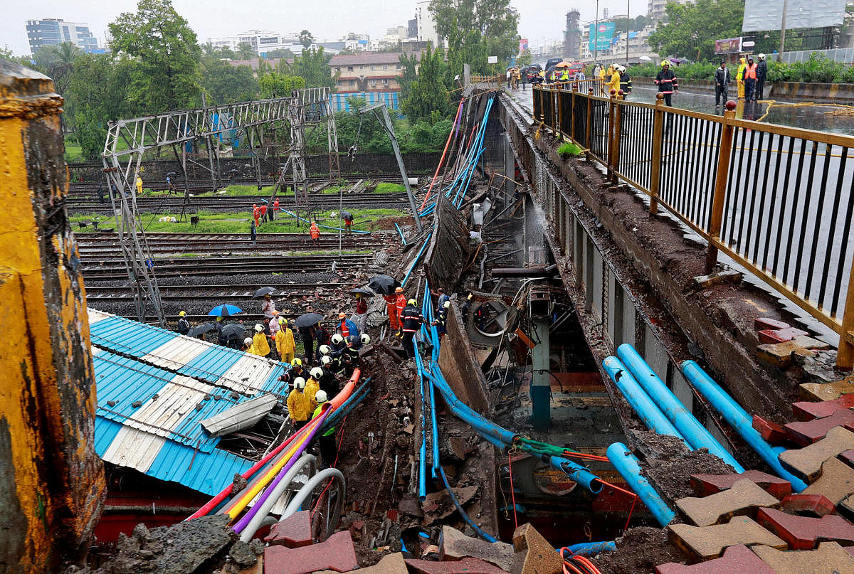 Rescue workers seen working at the site of an overbridge that collapsed over the railway tracks after heavy rains in Mumbai. REUTERS Photo