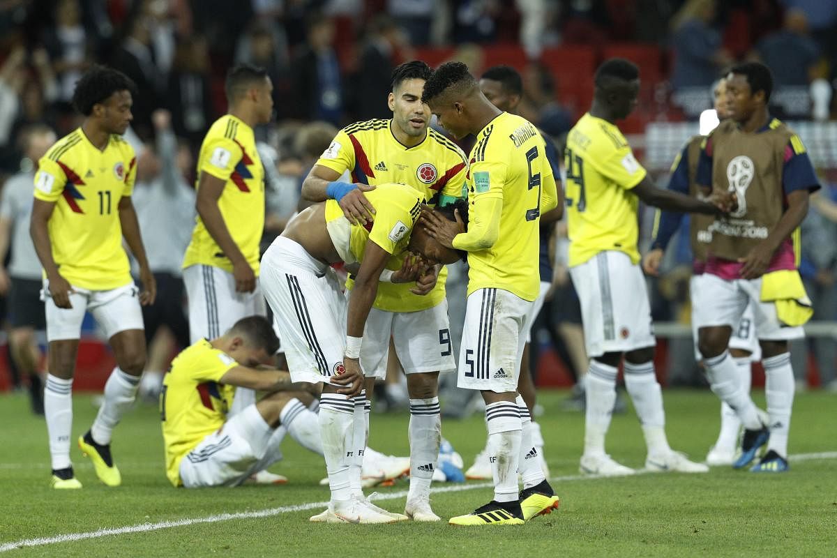 TOUGH NIGHT: Colombians players try to console each other after suffering an agonising loss to England on Tuesday. (AP/PTI Photo)