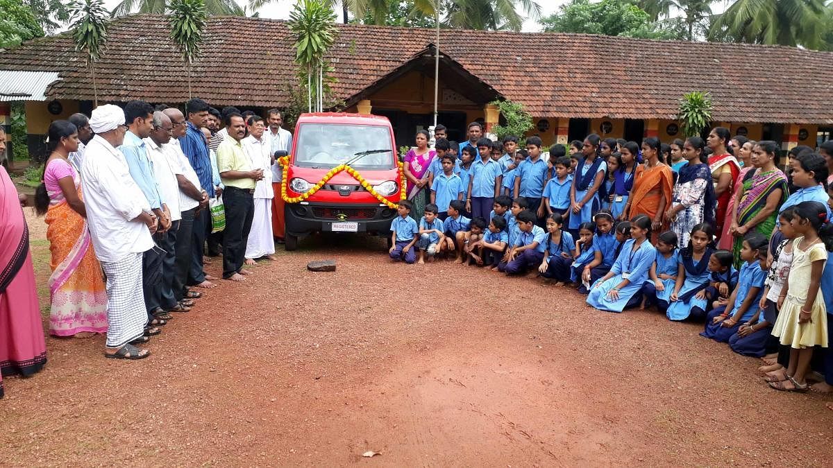 The residents of Kolnadu, Bantwal taluk, and the students of the Kulalu Government Model Higher Primary School seen with the new school vehicle.