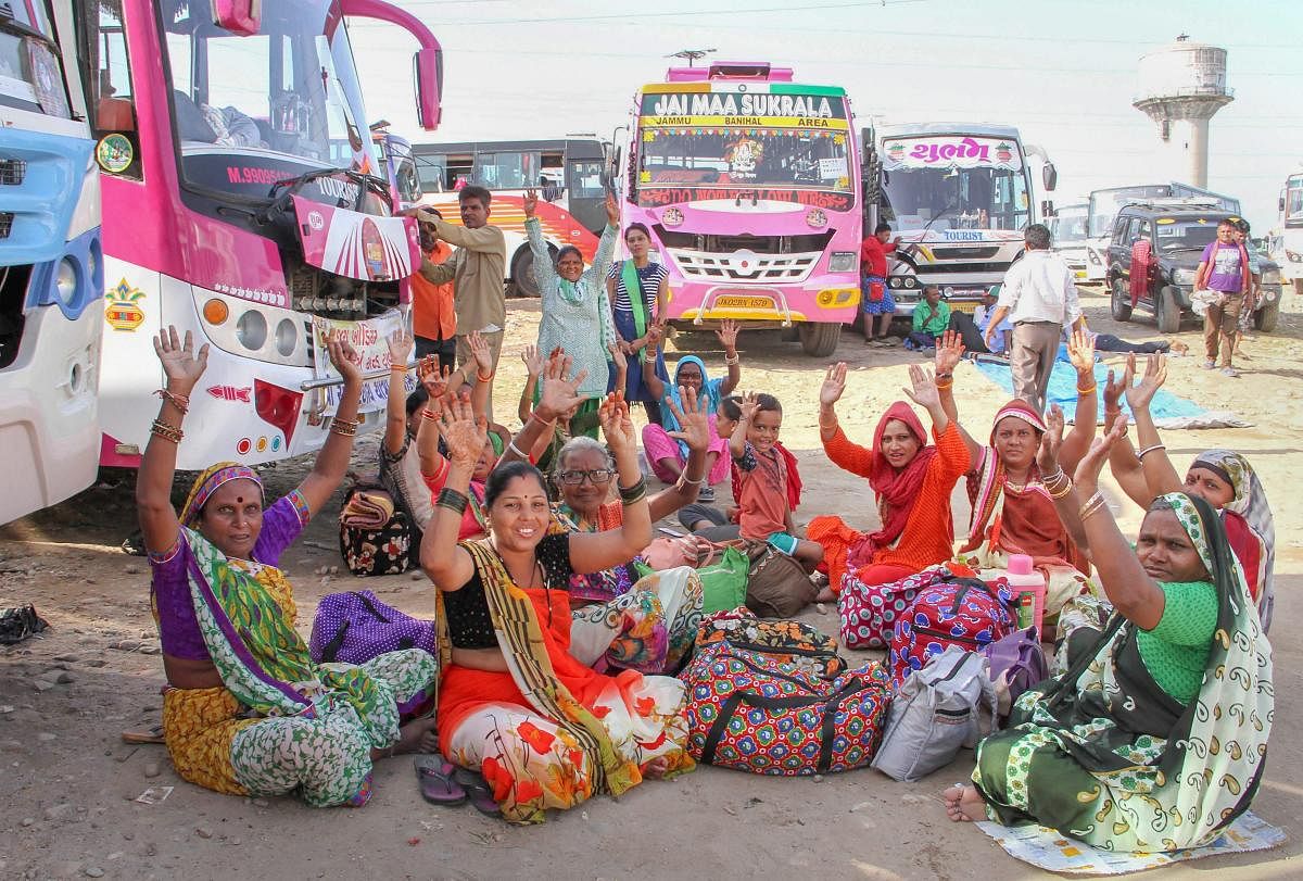 Amarnath pilgrims chant 'Bhajans' at their base camp after the yatra was suspended due to bad weather, in Jammu on Thursday. PTI Photo
