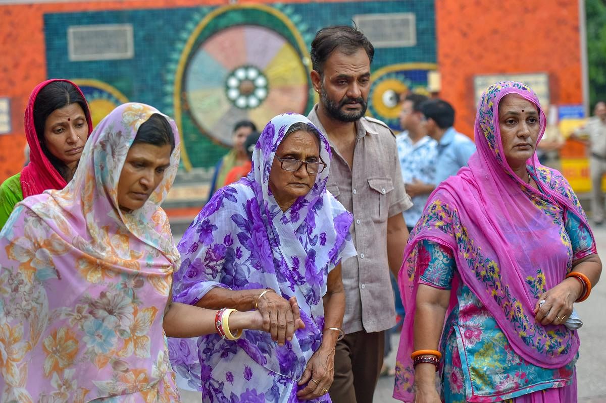 Relatives mourn during cremation of the 11 members of a family, who were found hanging in their house in Burari, at Nigambodh Ghat in New Delhi. PTI Photo