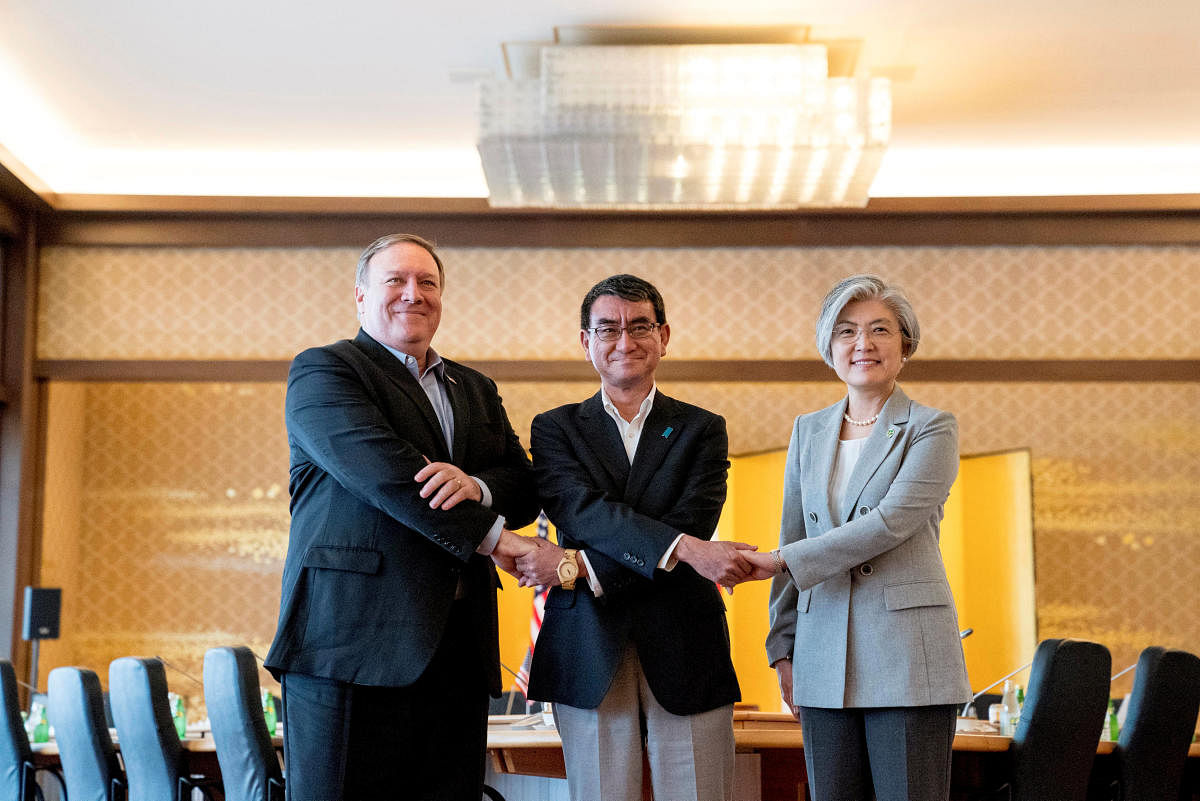 Mike Pompeo, Japan's Foreign Minister Taro Kono and South Korea's Foreign Minister Kang Kyung Wha shake hands for members of the media as they meet in Tokyo. Reuters