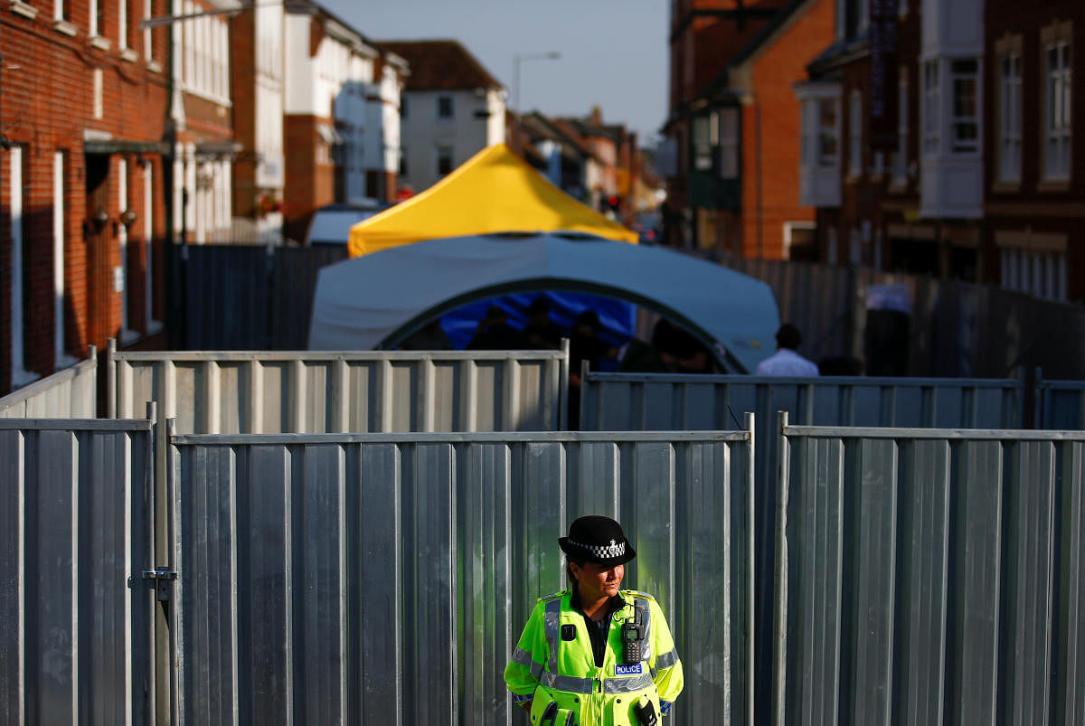 A police officer stands in front of screening erected behind John Baker House, after it was confirmed that two people had been poisoned with the nerve-agent Novichok, in Amesbury, Britain. (Reuters File Photo)