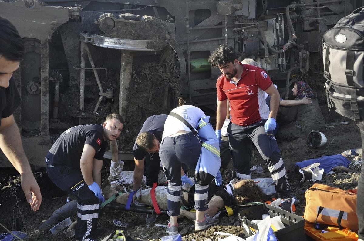 Services rescue victims from overturned train cars near a village in Tekirdag province, Turkey Sunday, July 8, 2018. At least 10 people were killed and more than 70 injured Sunday when multiple cars of a train derailed in western Turkey, a Turkish officia