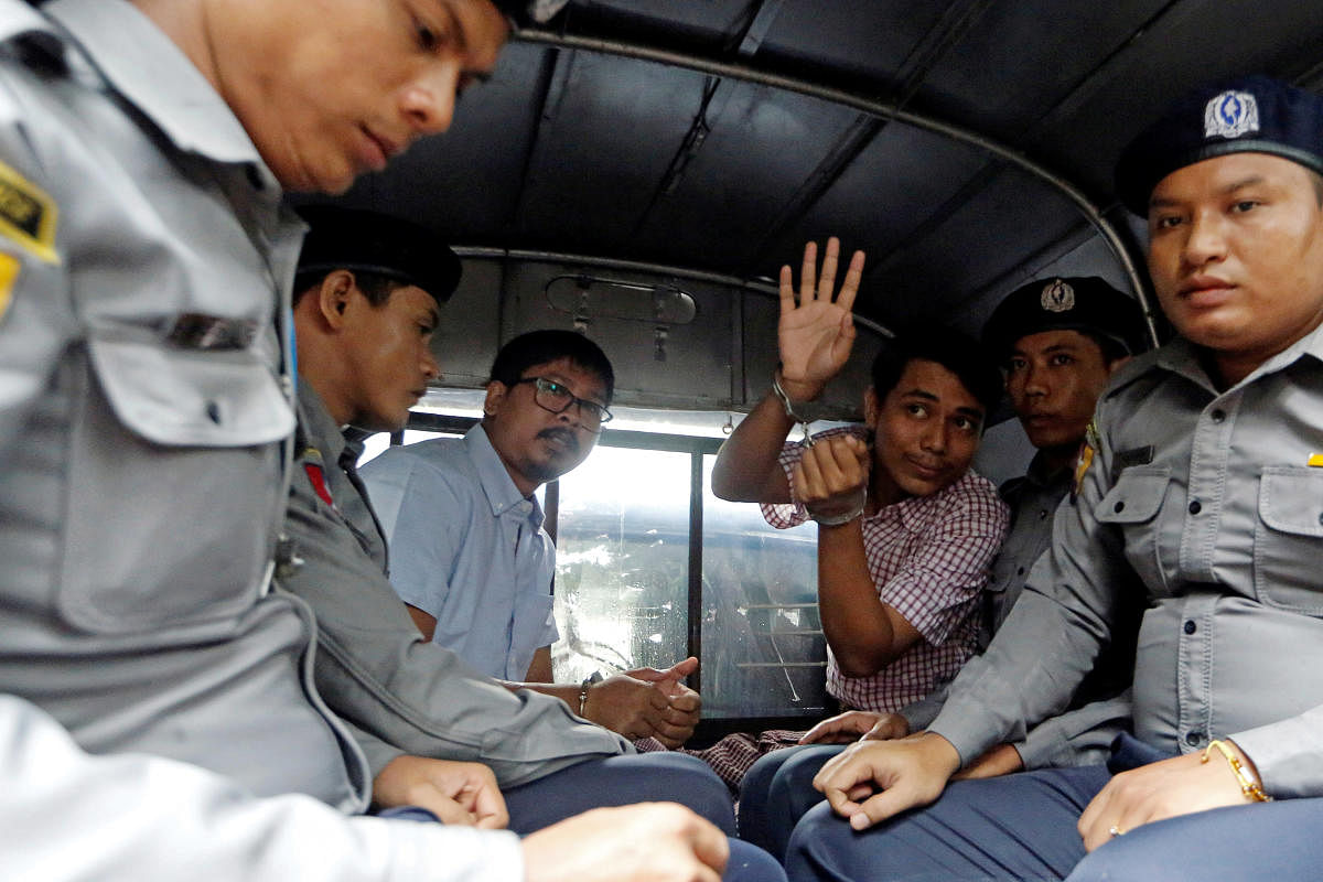 Detained Reuters journalist Wa Lone and Kyaw Soe Oo sit beside police officers as they leave Insein court in Yangon, Myanmar. (Reuters Photo)