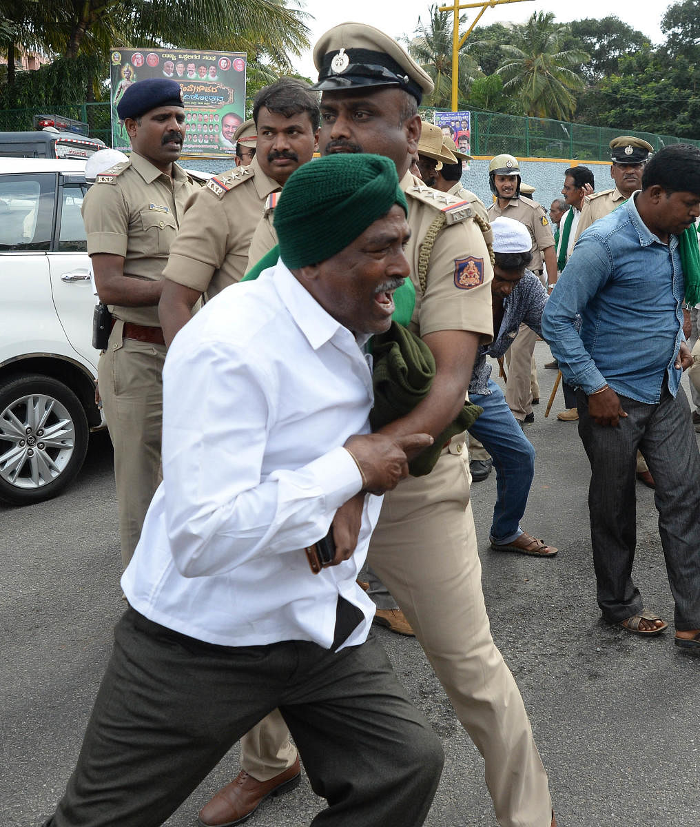 A policeman detains a protester near the Freedom Park on Monday. DH Photo/Satish Badiger