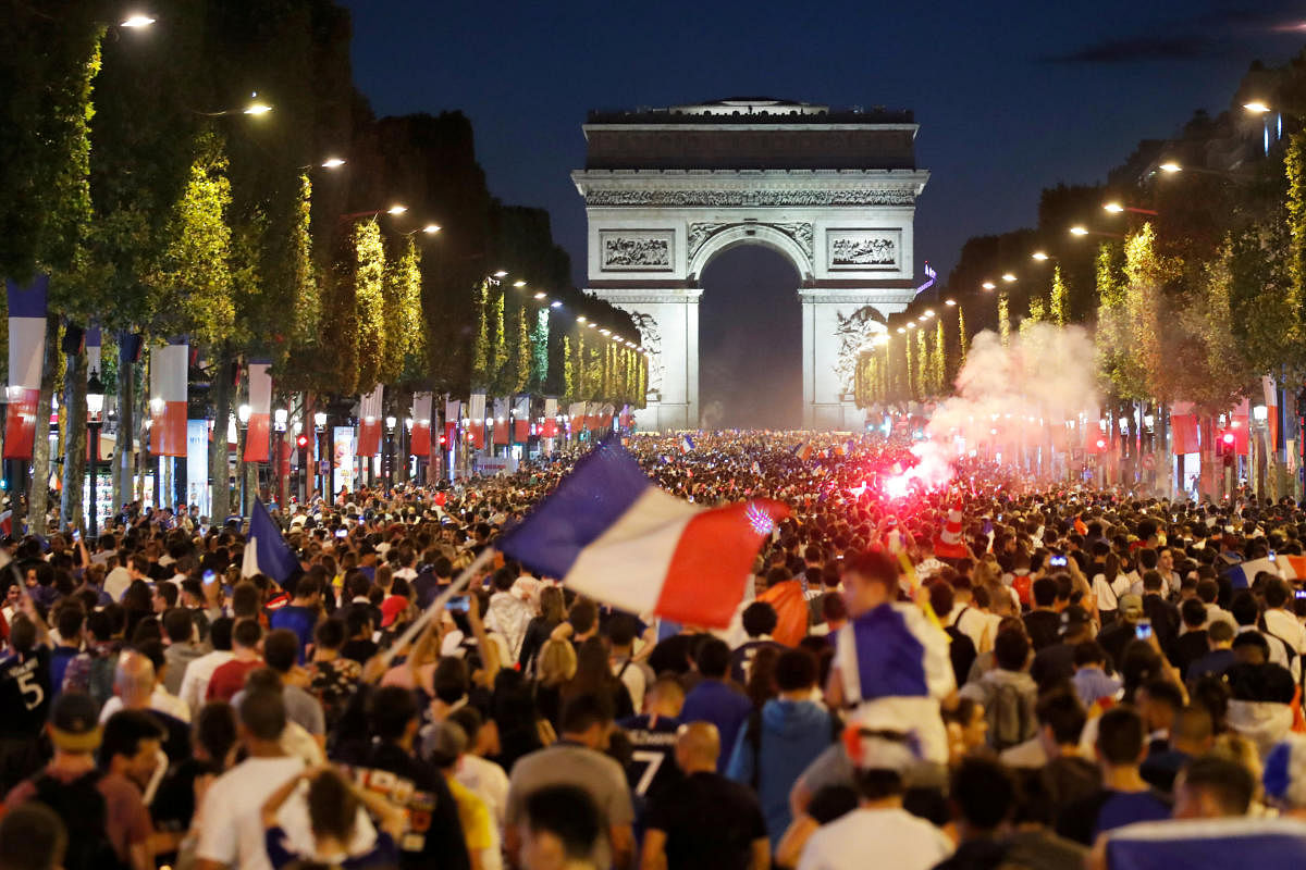PARTY TIME French fans throng the Champs-Elysees on Tuesday night after the Les Blues stormed into the final of the World Cup. (Reuters Photo)