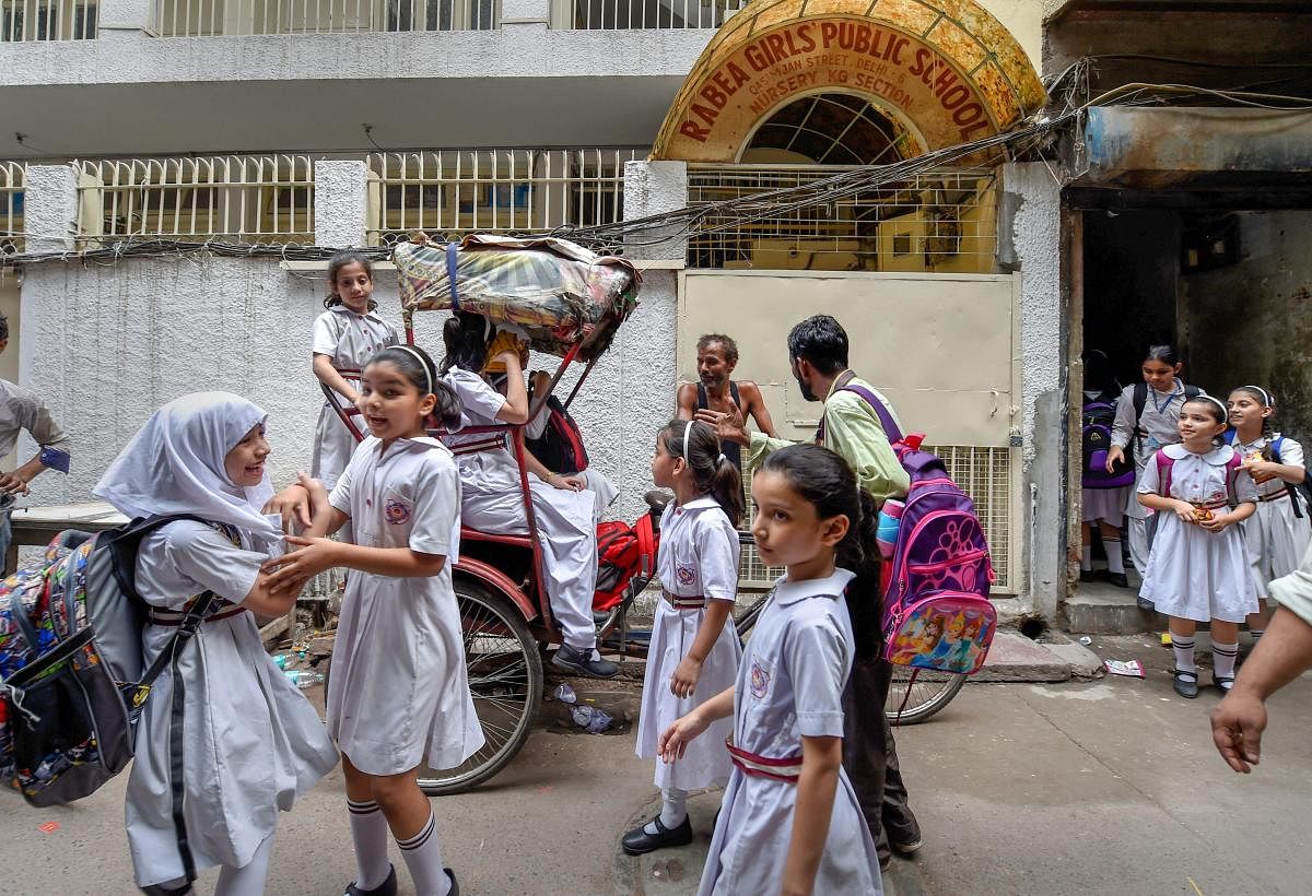 Rabea Girls' Public School Primary School students are seen outside the nursery and KG section of the school, where students were reportedly confined in the basement of the premises over the delay in payment of fees, at Chandni Chowk in New Delhi on Wednesday. (PTI Photo)