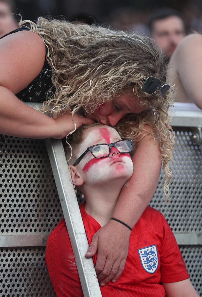 A young England fan is consoled as he watches his team's defeat to Croatia in Manchester.AP/ PTI
