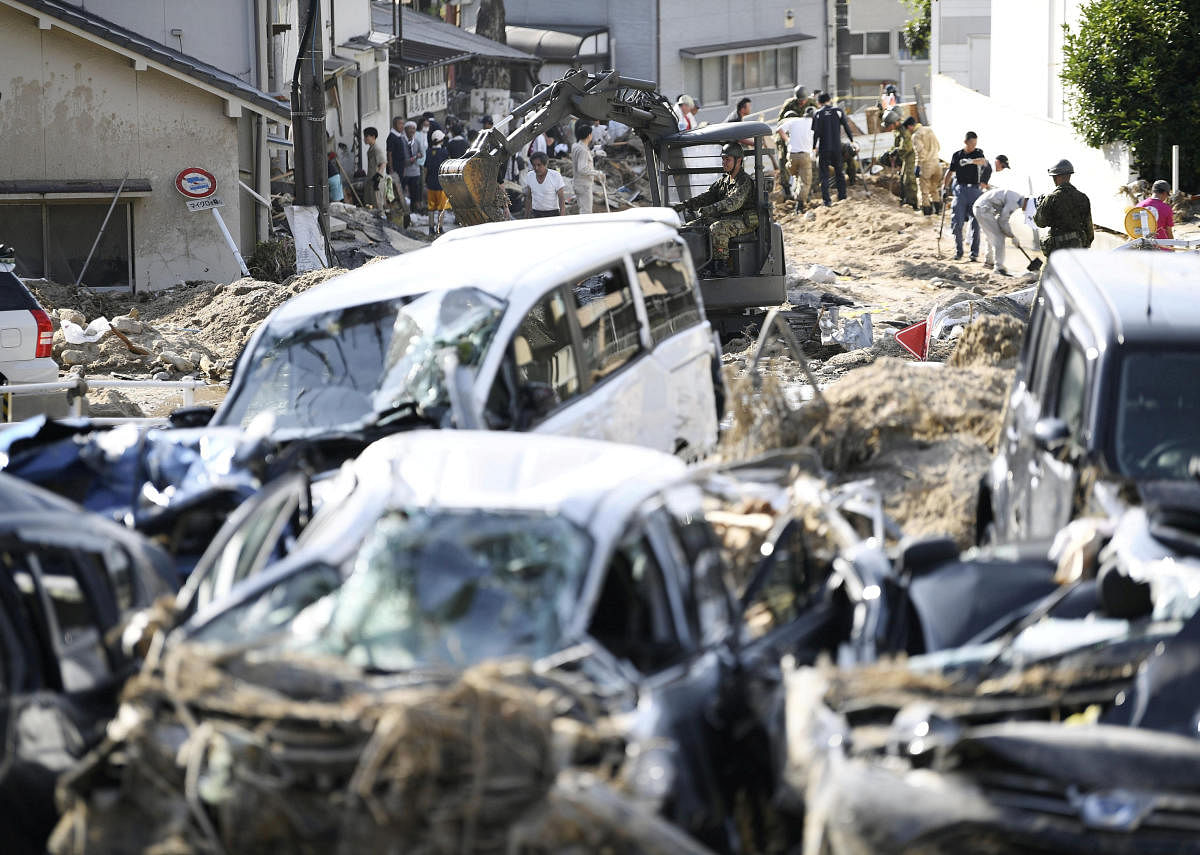 People clear debris caused by torrential rain at Aki ward in Hiroshima. Kyodo/Reuters.