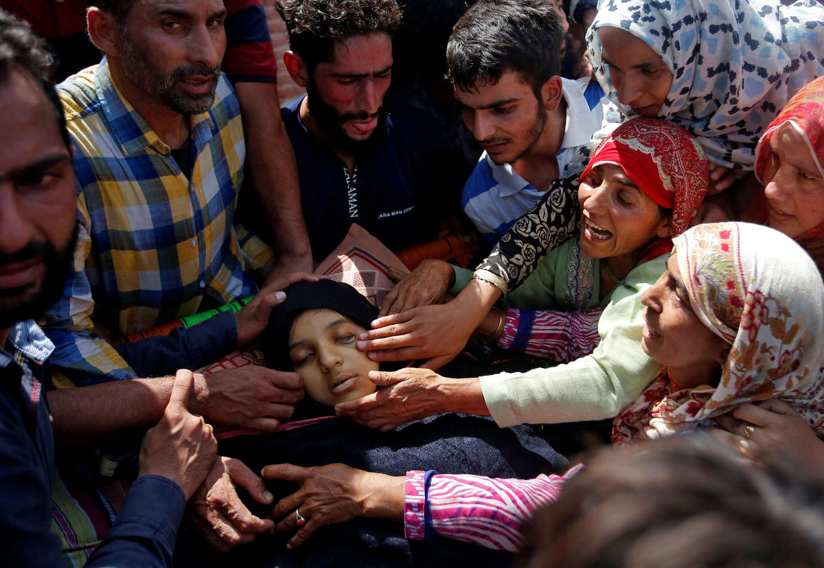 People react next to the body of 16-year-old girl Andleeb Jan, a civilian who according to local media died during clashes between protesters and Indian security forces, during her funeral i