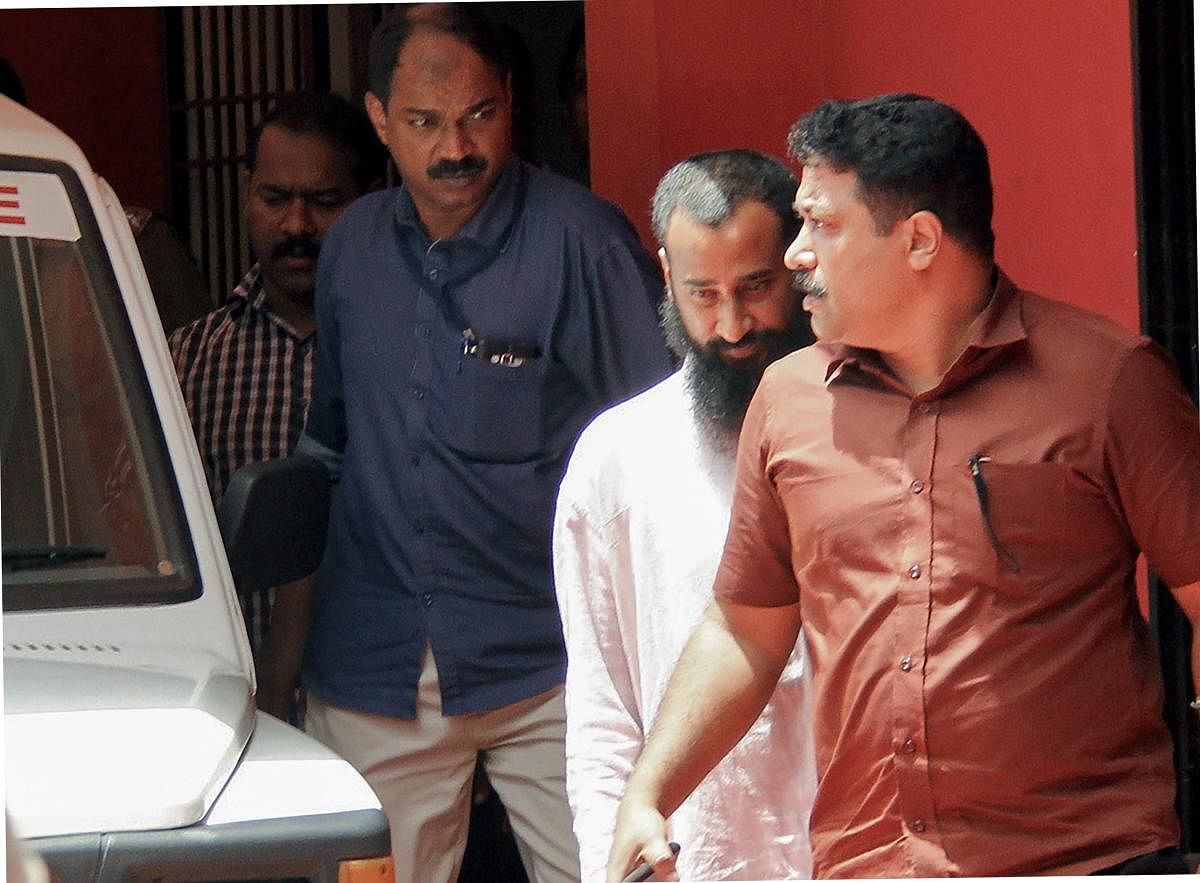 Malankara Orthodox Syrian Church priest Job Mathew (2nd R) being arrested soon after he surrendered before the Kollam Crime Branch in Kerala in connection with a rape and molestation case, in Kollam on Thursday. (PTI Photo)