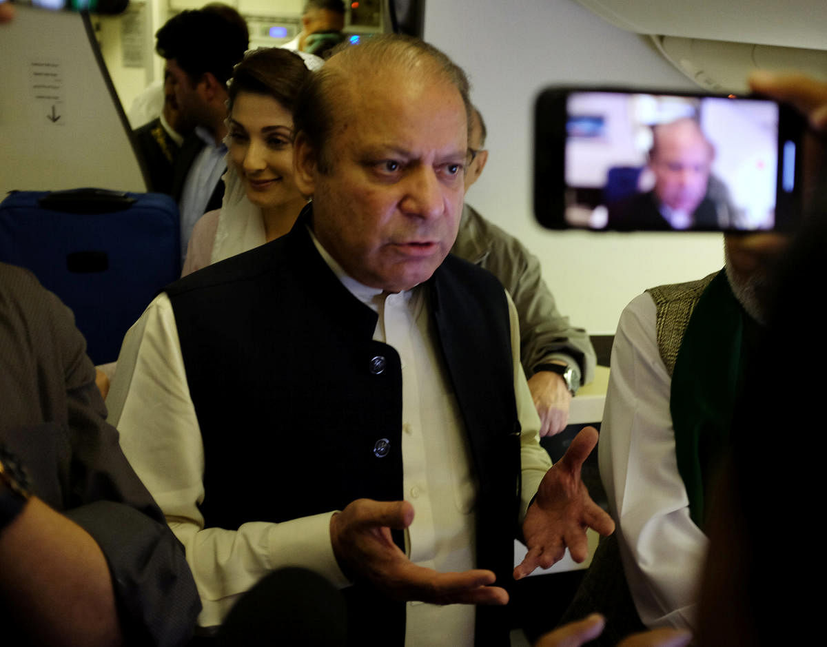 Ousted Pakistani Prime Minister Nawaz Sharif gestures as he boards a Lahore-bound flight due for departure, at Abu Dhabi International Airport. (Reuters Photo)