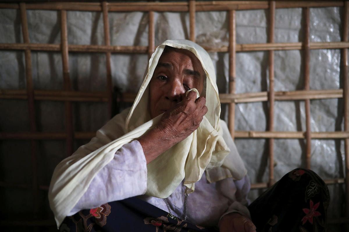 Roshan Begum, a Rohingya refugee, wipes her eyes after hearing the news that her son has been found in Buthidaung prison in Myanmar through trace message request program of Bangladesh Red Crescent Society Bangladesh, at a camp in Cox's Bazar, Bangladesh,