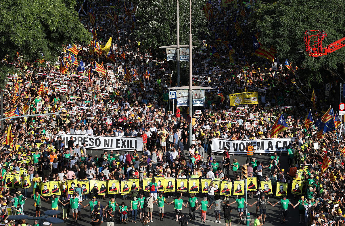 People hold banners during a protest against the imprisonment of the Catalan separatist leaders in Barcelona, Spain, July 14, 2018. The banner reads: "No prison, no exile, we want you at home". REUTERS.