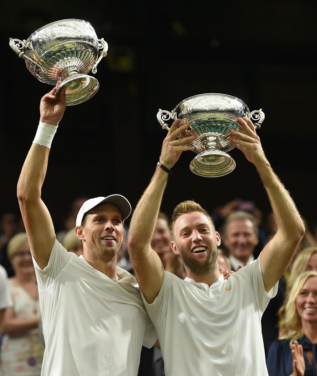 NEW ALLIANCE Americans Mike Bryan (left) and Jack Sock celebrate with the Wimbledon men's doubles trophies on Saturday. AFP