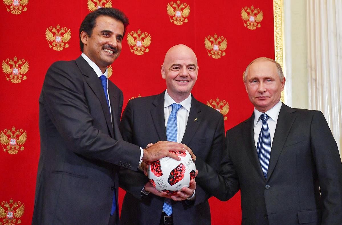 FIFA president Gianni Infantino (centre) takes the ball from Russian president Vladimir Putin (right) and passes it to Emir of Qatar Sheikh Tamim bin Hamad Al-Thani as a symbol of transfer of authority to Qatar for hosting the FIFA World Cup 2022. AFP