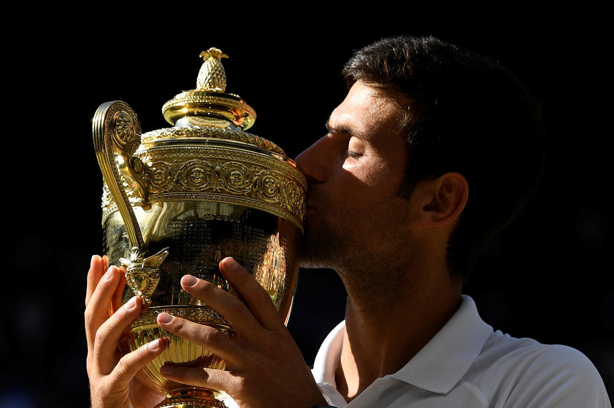 Serbia's Novak Djokovic celebrates with the trophy after winning the men's singles final against South Africa's Kevin Anderson. (REUTERS/Tony O'Brien)