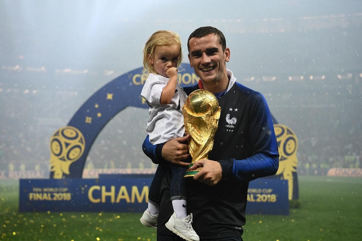 France's forward Antoine Griezmann poses with his daughter and their World Cup trophy after winning the Russia 2018 World Cup final football match between France and Croatia at the Luzhniki Stadium in Moscow on July 15, 2018. (AFP PHOTO)