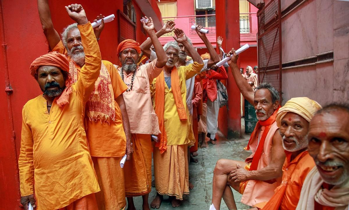 Sadhus chant religious slogans while standing in a queue to get themselves registered for Amarnath Yatra at a base camp, in Jammu on Thursday, July 12, 2018. PTI photo