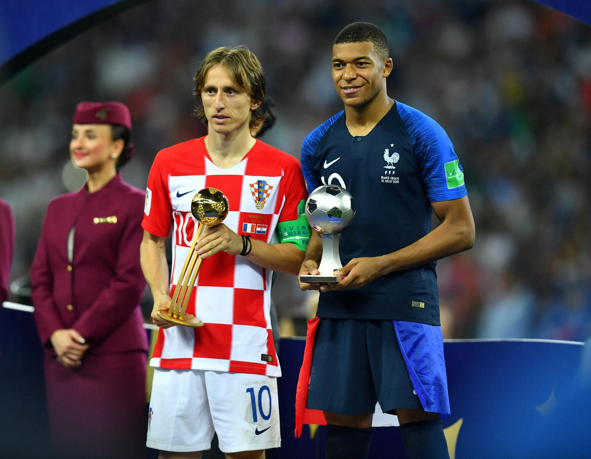 Croatia's Luka Modric poses with the World Cup Best Player Award as France's Kylian Mbappe poses with the World Cup Best Young Player Award. (REUTERS/Dylan Martinez)