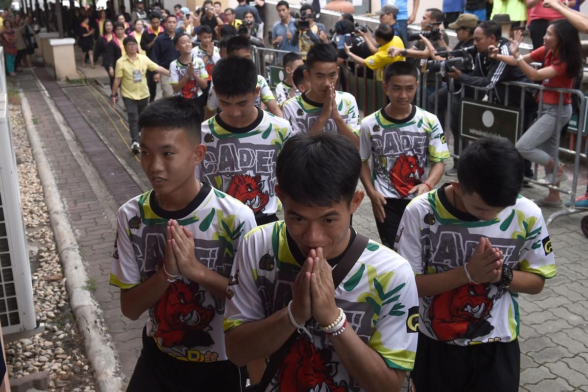 Twelve boys and their football coach Ekkapol Chantawong (C), dramatically rescued from deep inside a Thai cave after being trapped for more than a fortnight, arrives for a press conference in Chiang Rai. AFP photo
