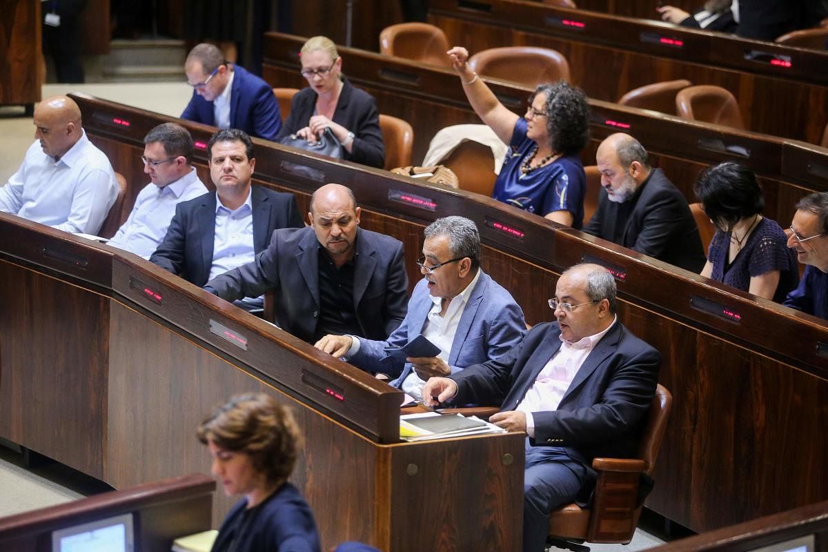 Israeli-Arab Member of Parliament Ahmed Tibi (front row-R) attends with fellow deputies the Knesset Plenary Hall session ahead of the vote on the National Law late on Wednesday. AFP