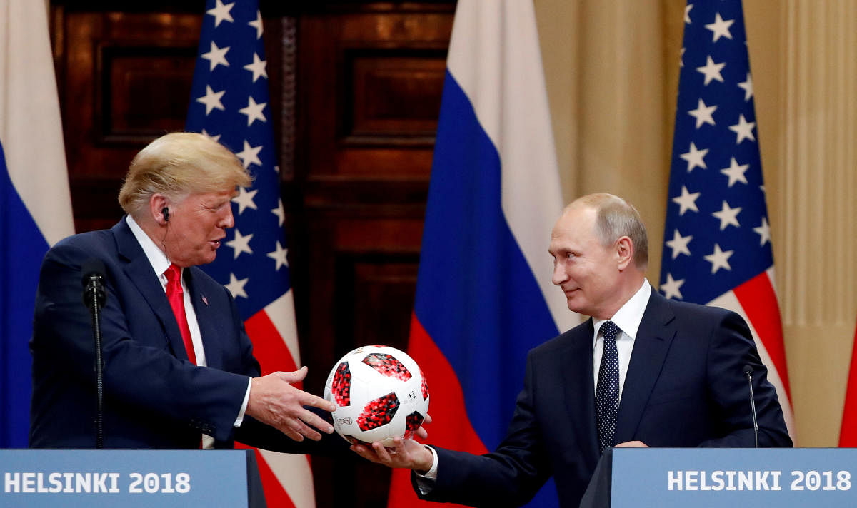 U.S. President Donald Trump receives a football from Russian President Vladimir Putin as they hold a joint news conference after their meeting in Helsinki, Finland July 16, 2018. REUTERS File Photo