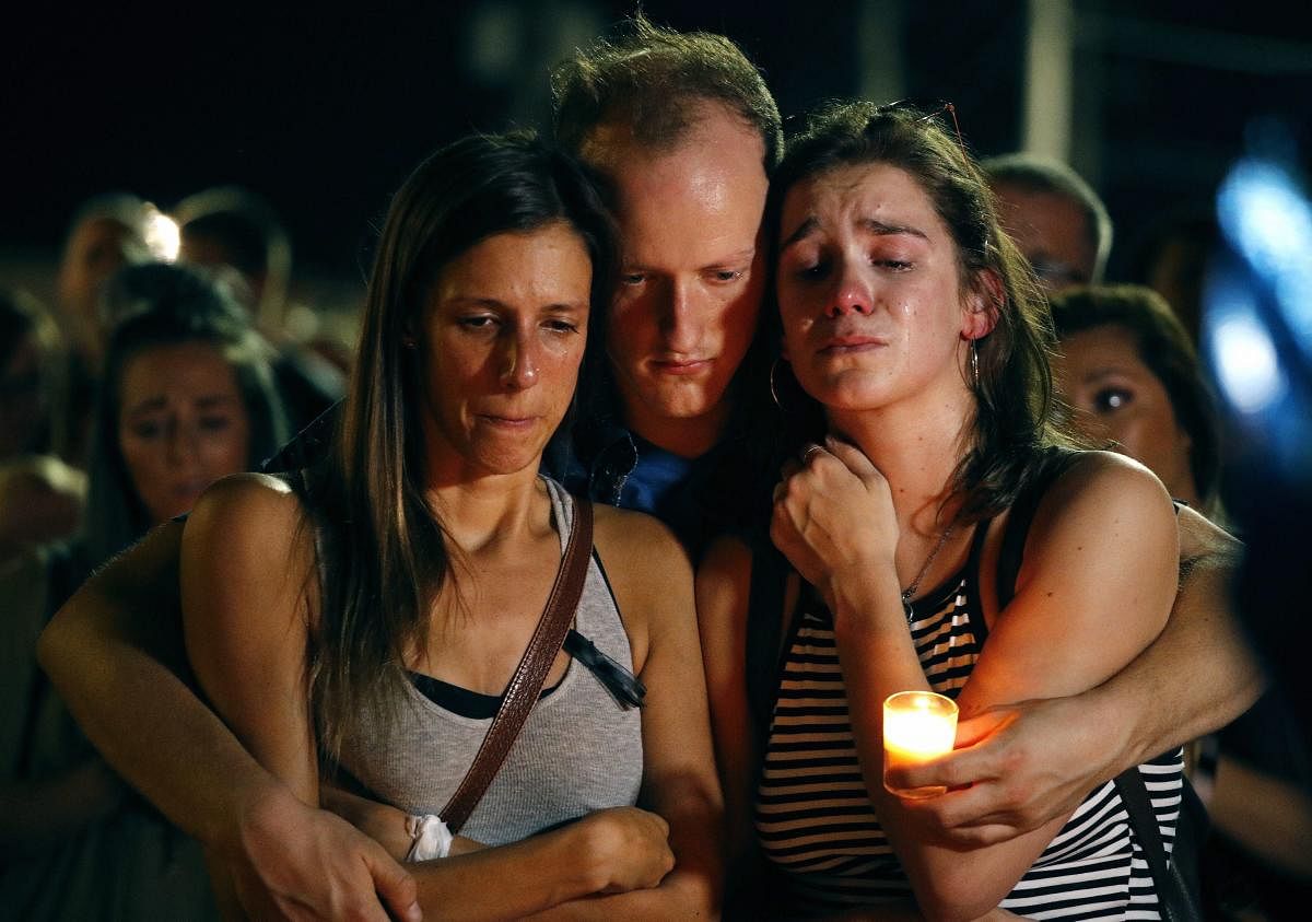 Mallory Cunningham, left, Santino Tomasetti, center, and Aubrey Reece attend a candlelight vigil in the parking lot of Ride the Ducks Friday, July 20, 2018, in Branson, Mo. One of the company's duck boats capsized Thursday night resulting in over a dozen deaths on Table Rock Lake. AP/PTI