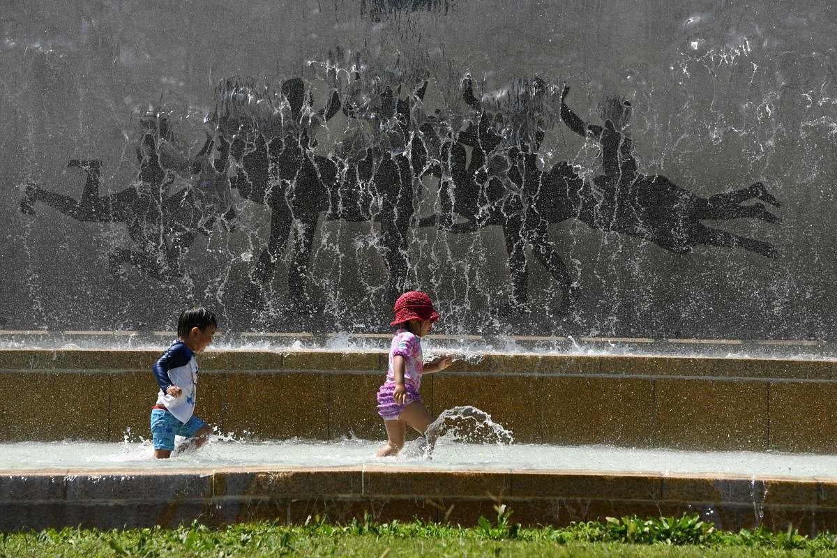 Children play in a water fountain in a Tokyo park, as a heatwave grips Japan, on July 20, 2018. AFP Photo