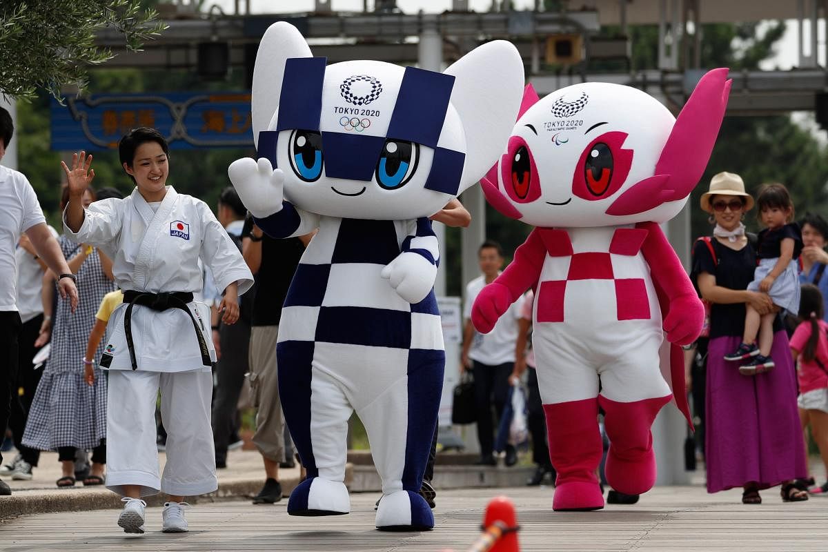 Tokyo 2020 Olympics mascot Miraitowa (centre) and Paralympic mascot Someity wave with Japanese karateka Kiyo Shimkizu (left) in Tokyo on Sunday. AFP