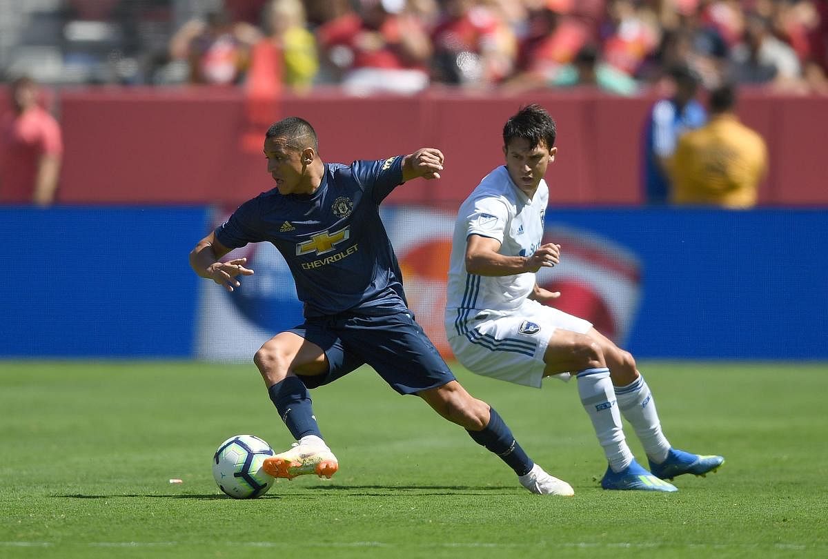 Manchester United's Alexis Sanchez gets past Shea Salinas of San Jose Earthquakes during their game on Sunday. AFP