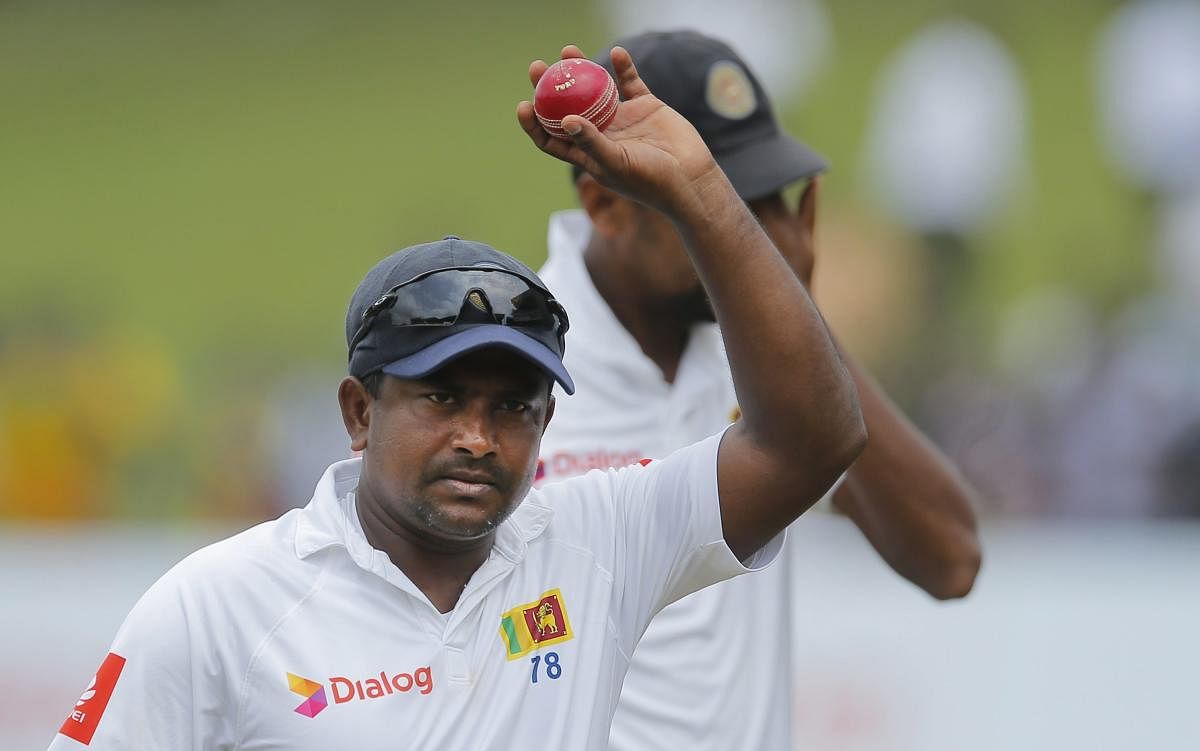AGELESS WARRIOR: Rangana Herath holds the match ball and acknowledges the crowd after his six-wicket haul helped Sri Lanka drub South Africa in the second Test. AP/PTI
