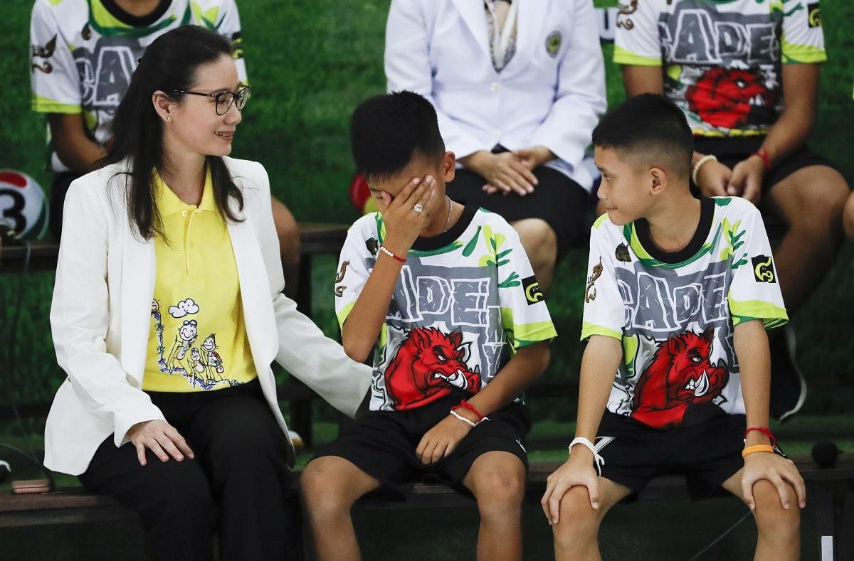 Rescued soccer player "Titan" Chanin Vibulrungruang reacts after paying respect to a portrait of Saman Gunan, the Thai Navy SEAL diver who died in the rescue attempt, during a press conference discussing their ordeal in Chiang Rai, northern Thailand, Wedn