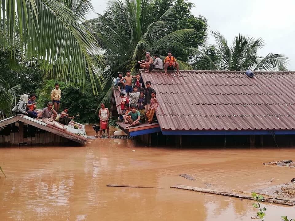 People take refuge on the roof of a house following a dam's collapse in Laos. Twitter photo.