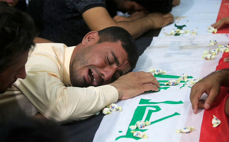 A man mourns at the funeral of the security men who were kidnapped and killed by Islamic State militants, in Kerbala, Iraq June 28, 2018. REUTERS/Alaa al-Marjani