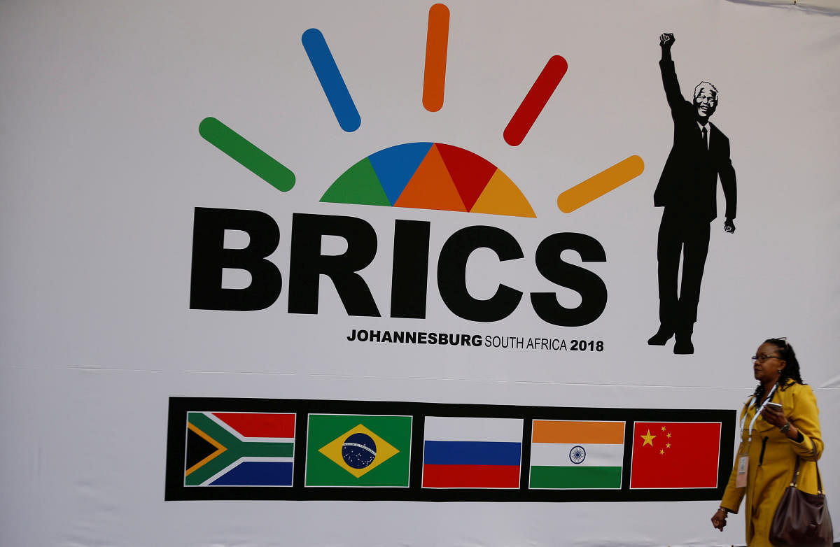 A delegate walks past a BRICS logo ahead of the 10th BRICS Summit, in Sandton, South Africa, July 24, 2018. REUTERS