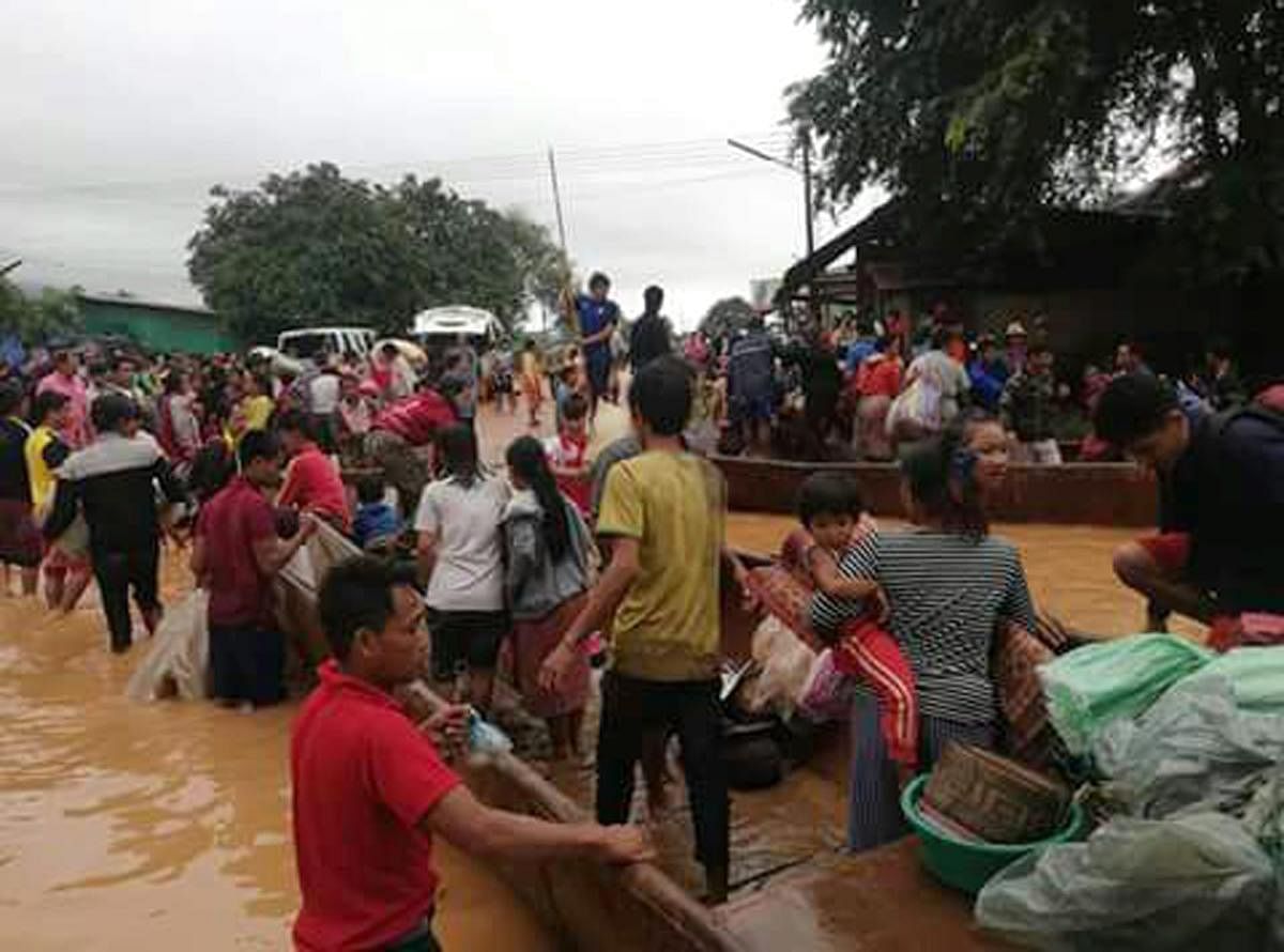 In this Tuesday, July 24, 2018, image from video, people are evacuated through the floodwaters from a collapsed dam in southeastern Laos. Rescue efforts are ongoing in villages flooded after part of a newly built hydroelectric dam was breached in southeas