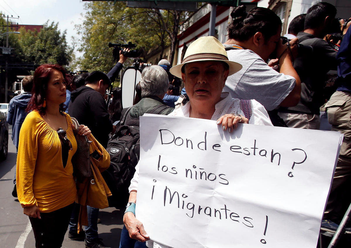 A demonstrator holds a placard reading "Where are the migrant children?" while protesting outside the headquarters of Mexico's President-elect Andres Manuel Lopez Obrador prior to the meeting with U.S. Secretary of State Mike Pompeo and other top U.S. officials in Mexico City, Mexico July 13, 2018. (REUTERS/Gustavo Graf)