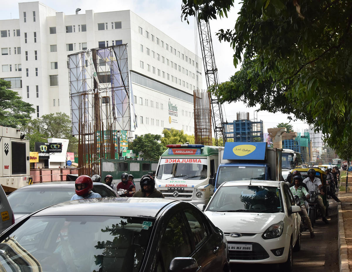 An ambulance is stuck in a traffic jam on Bannerghatta Road where metro work is underway. DH Photo/Janardhan B K