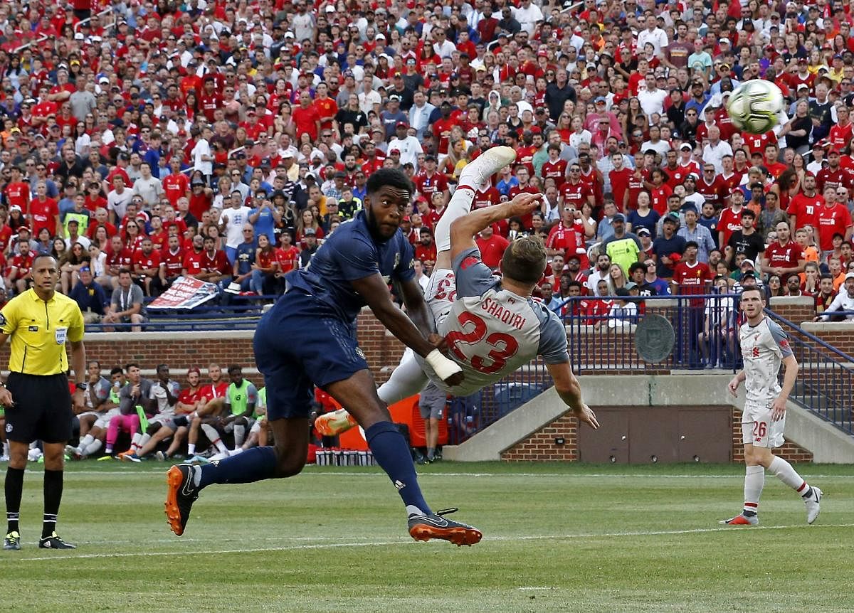 Stunning: Liverpool's Sheridan Shaqiri (right) scores a spectacular bicycle-kick goal against Manchester United on Saturday. AFP