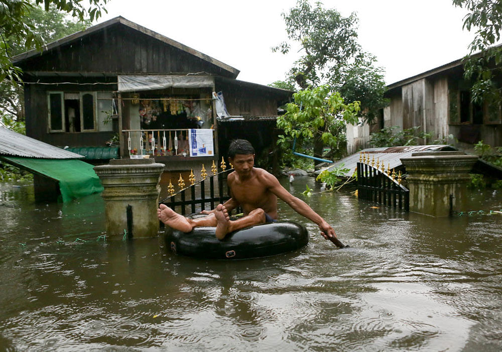 A man travels through a flooded street in Bago, Myanmar. REUTERS